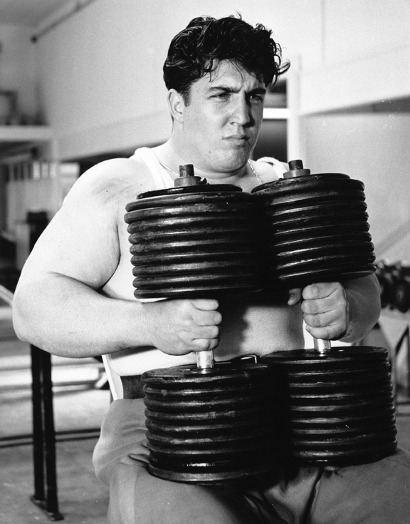 It's 1963 and Pat Casey walks a pair of 210s from the rack to an incline bench for 8 reps and then walks them back to the rack, all unassisted. Leo Stern photo.