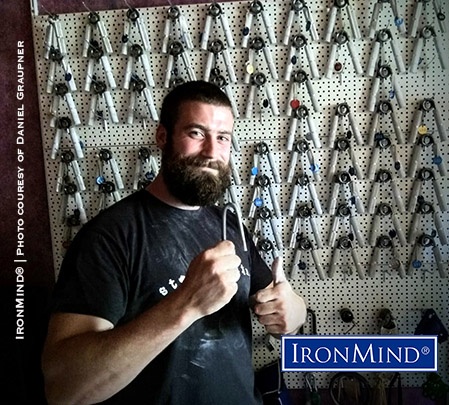 Germany’s Daniel Graupner poses with the IronMind Red Nail he bent under official conditions, leading to his certification.  Incidentally, that formidable collection of Captains of Crush grippers belongs to Daniel's referee, Joerg Keilbach. IronMind® | Photo courtesy of Daniel Graupner
