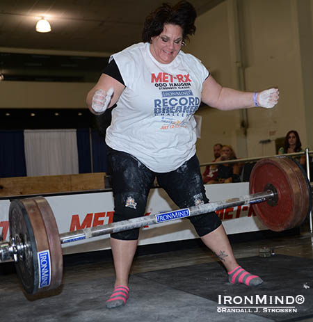In her excitement at easily pulling this 131-kg Apollon’s Axle Double Overhand Deadlift, Amy Wattles dropped the bar after completing the lift, and so got it turned down and had to repeat.   Not a problem, though, as she did it again, and restamped her name on one of the most prestigious world records in the grip strength world. IronMind® | Randall J. Strossen photo