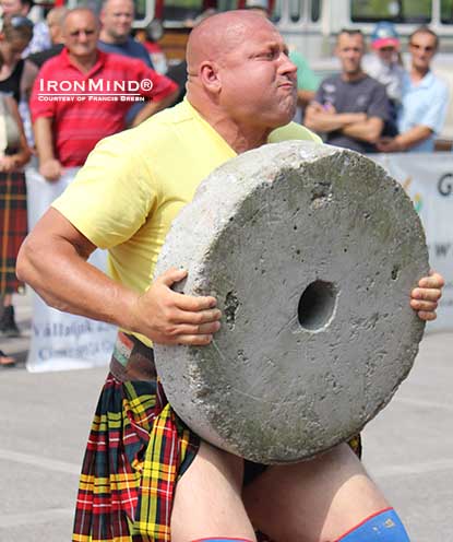 Adam Darusz (shown on the 130-kg mill stone), as part of the IHGF, is helping to advance the Highland Games heavy events and related strength competitions in his native Hungary and surrounding countries.  Photo courtesy of Francis Brebner.