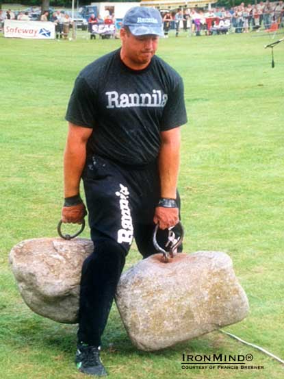 “A major IHGF stone lifting competition is being scheduled to take place in Scotland between the 19th and 20th of June this year to see who can officially walk the farthest with both of the Dinnie Stones at the same time,” IHGF president Francis Brebner told IronMind today.  Callum Morrison, one of the few men in the world to walk with both Dinnie Stones at once.  IronMind® | Photo courtesy of Francis Brebner.  “In 1997 Callum Morrison of Aboyne was the first person on record to officially walk with both stones at the same time a distance of 2’ which Callum then later increased this distance to 5‘ and  the official record is currently held by Glenn Ross of Ireland with a distance of 5’ 5” set in 2001,” said Brebner.  “A memorial trophy in tribute of Callum Morison who passed away last year at the age of only forty eight will be awarded in this particular event for the athlete that can walk the farthest with both stones at the same time.  “Other stone events to be included also, athletes competing to be released on IronMind, a few more spots are still open for competitors   . . . this event will be filmed for European TV,” said Brebner.                                                                   ###   The IronMind Forum: discuss this article, talk strength, get help with your training. http://www.ironmind-forum.com/forum.php    You can also follow IronMind on Twitter.  https://twitter.com/IronMind