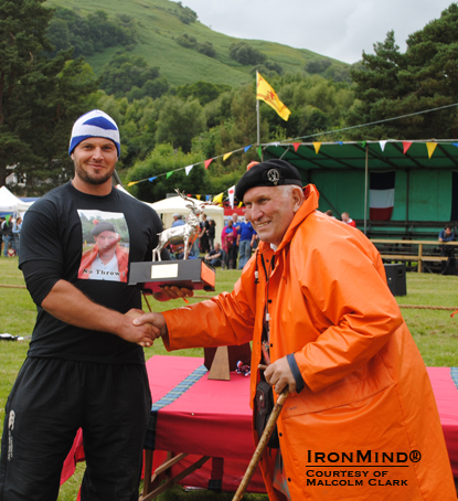 Gregor Edmunds receives the Stag trophy at Luss from the great Jock McColl of Oban.  IronMind® | Photo courtesy of Malcolm Clark.