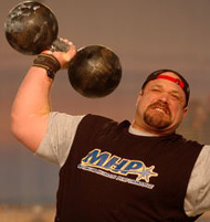 Hugo Girard (Canada) banging out reps in the Inch dumbbell press at the 2005 Arnold strongman contest (Columbus, Ohio). IronMind® | Randall J. Strossen, Ph.D. photo.