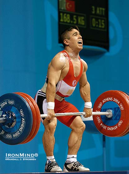 Happier days for the Turkish Weightlifting Federation: Halil Mutlu had just won his third consecutive Olympic gold medal in Athens and then the 56-kg weightlifter managed to rack this 168.5 kg (although he was unable to stand up with it), in an effort to break his own world record in the clean and jerk.  IronMind® | Randall J. Strossen photo.