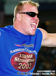 Phil "The Wolfman" Pfister growls as he hangs on during the Hercules Hold at the 2003 US Championships, put on by Jim Davis in St. Louis. IronMind® | Randall J. Strossen, Ph.D. photo.