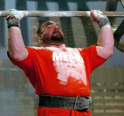 Schoonie pressing the Apollon Wheels at the 2004 Arnold Strongman competition: It might not be on the Olympic program any more, but pressing remains a fundamental test of strength, and if you made a short list of the top pressers in strongman, you'd find Brian Schoonveld's name in the thick of things. IronMind® | Randall J. Strossen, Ph.D. photo.