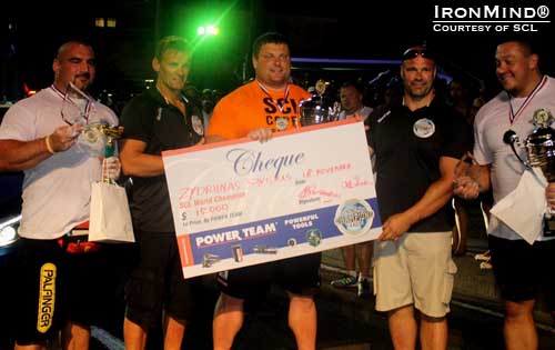 2012 champion Zydrunas Savickas receives a check for $15,000 from Marcel Mostert and Ilkka Kinnunen, cofounders of SCL.  IronMind® | Photo courtesy of SCL.