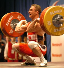 Artuc Sedat (Turkey) hits the bottom with his 155-kg clean and jerk, on his way to a gold medal performance in the 56-kg category at the 2004 European Weightlifting Championships (Kiev, Ukraine). IronMind® | Randall J. Strossen, Ph.D. photo.