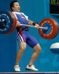 62-kg Shi Zhiyong (China) pulls himself under this 172.5-kg clean, on his way to a gold medal at the 2004 Olympics (Athens, Greece). IronMind® | Randall J. Strossen, Ph.D. photo.