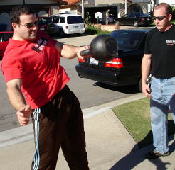 Turning the Belanger driveway into a gym, Zach Passman cranks on a kettlebell under the watchful eye of Brett Jones, one of Pavel Tsatsouline's instructors. Multi-talented, both Zach and Brett are on the Red Nail™ Roster. IronMind® | Randall J. Strossen, Ph.D. photo.