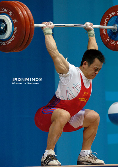 69-kg Zhang Guozheng (China) nailed this 187.5-kg squat jerk en route to his gold medal performance at the 2004 Olympics.  Zhang and his teammate, Shi Zhiyong, also a squat jerker and a 2004 Olympic gold medalist, were the headliners at the IronMind Invitational at the 2005 Arnold, where strongman competitors Odd Haugen and Svend Karlsen were glued to the Expo stage waiting to see them squat jerk.  IronMind® | Randall J. Strossen photo.