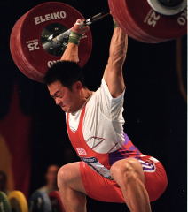 Chinese weightlifting star Zhang Guozheng squat jerks his opener, 187.5 kg, at the 2003 World Weightlifting Championships (Vancouver, British Columbia). Zhang Guozheng and his teammate Shi Zhiyong, both gold medalists at the Athens Olympics, along with their coach, Chen Wenbin, will exhibit their extraordinary talent at the 2005 Arnold. Consider this an hors d'oeuvre for the Beijing Olympics. IronMind® | Randall J. Strossen, Ph.D. photo.