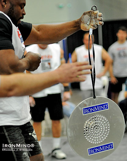 Mark Felix’s hand opens on the Captains of Crush No. 3 gripper and referee Mike Corlett signals for time as the CoC Silver Bullet is launched: Felix is credited with the inaugural world record as he held on for 43.25 seconds at the 2012 LA FitExpo.  IronMind® | Randall J. Strossen photo.