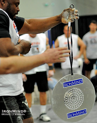 Exciting for competitors and fans alike, the CoC Silver Bullet tests crushing grip strength and endurance in a visually interesting way.  Here, Mark Felix’s hand opens on the Captains of Crush No. 3 gripper and referee Mike Corlett signals for time as the CoC Silver Bullet is launched: Felix is credited with the inaugural world record as he held on for 43.25 seconds at the 2012 LA FitExpo.  IronMind® | Randall J. Strossen photo.  IronMind® | Randall J. Strossen photo.